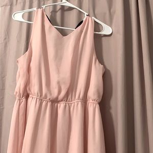 Long, flowy, light pink dress with a black bow